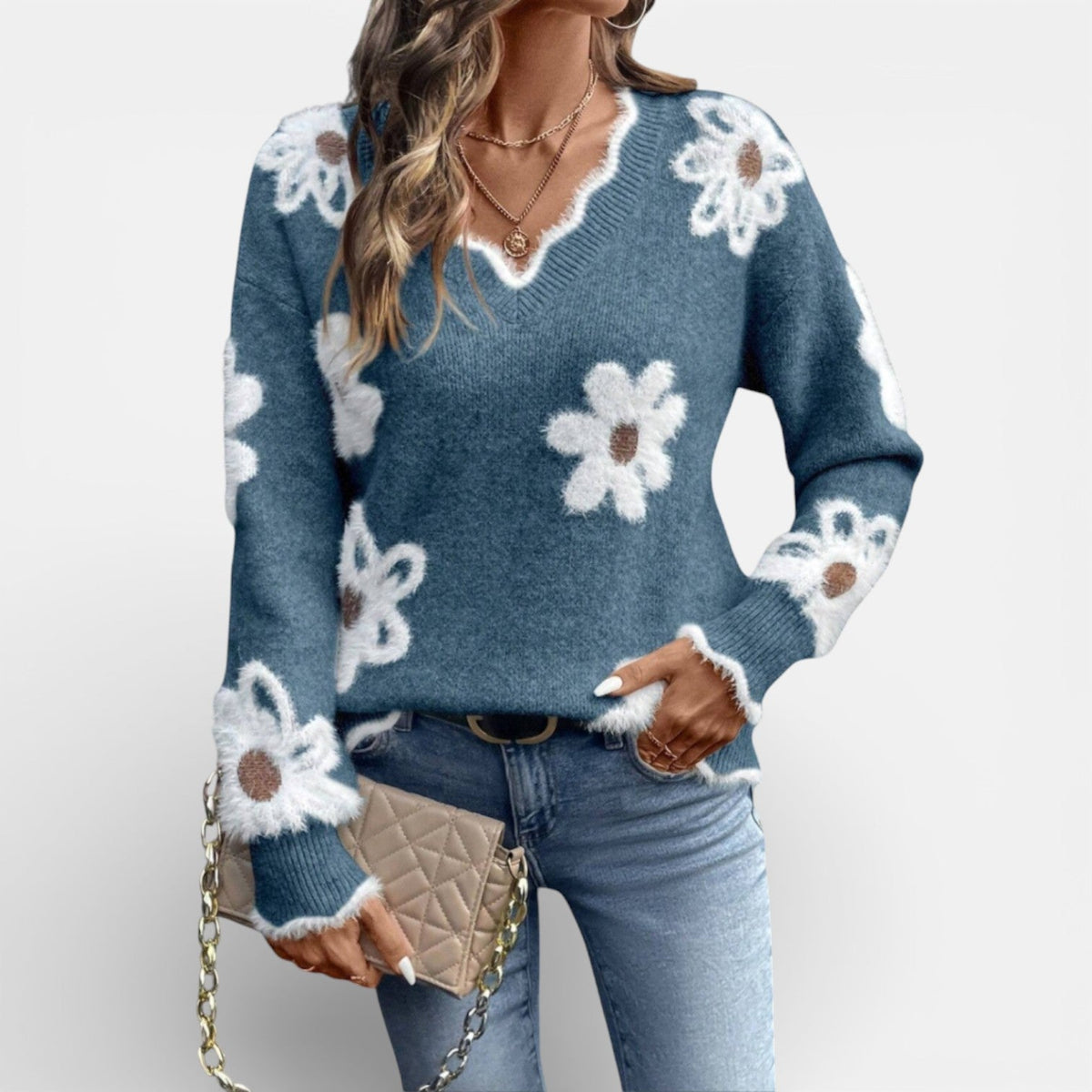 Zachte trui met pluizige witte bloemen en V-hals in blauw, gedragen met jeans