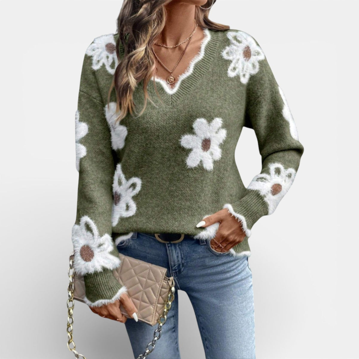 Zachte trui met pluizige witte bloemen en V-hals in groen, gedragen met jeans