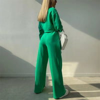 Achterkant van groene set met ruimvallende sweater en wijde pijpen