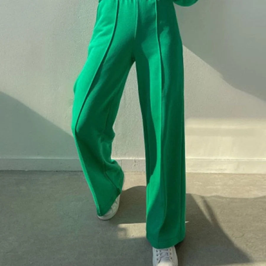 Groene wijde broek met persvouw gedragen op witte sneakers