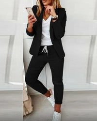 Zwarte blazerset met open blazer over een witte top