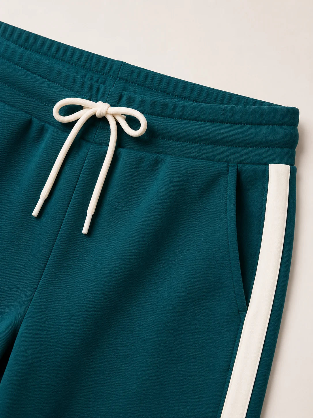 Detail van groene trainingsbroek dames met trekkoord en contraststreep
