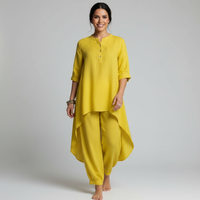 Vrouw in gele tuniek met knoopjes en losse broek