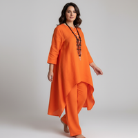 Vrouw in oranje tuniek met driekwart mouwen en losse broek