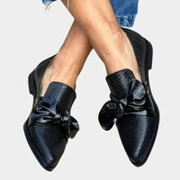 Detail van de geknoopte strik over de wreef van de loafer